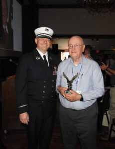 the eagle award is being presented to Alex Levy by Ken Hellendall on the stage of EDITS.